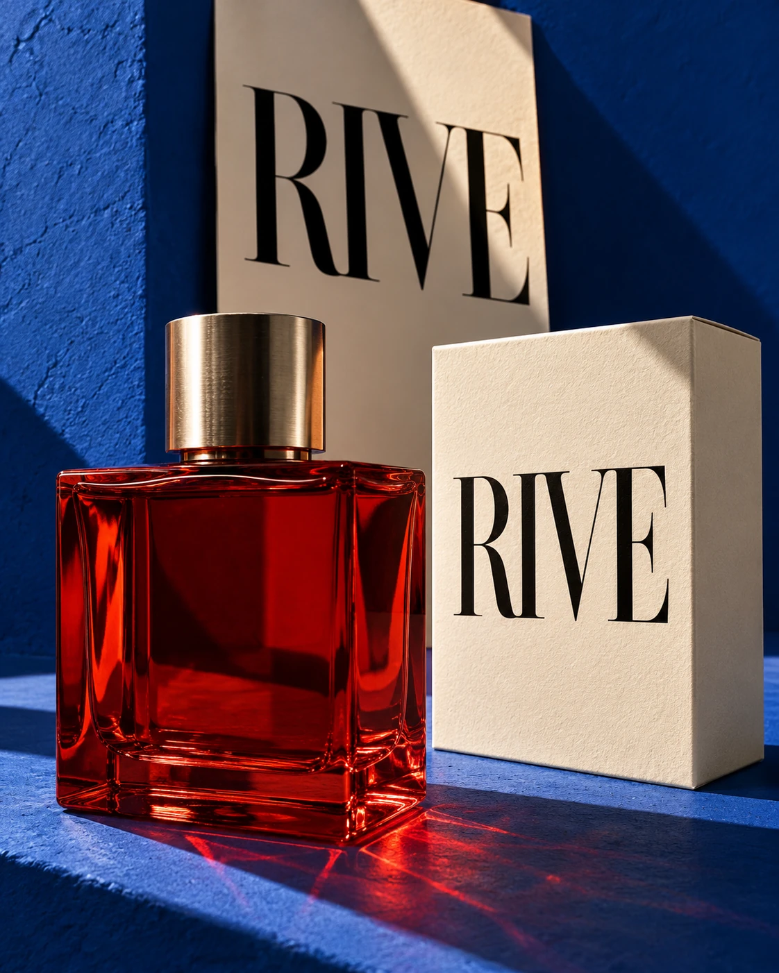 Rive, concept de direction artistique : flacon de parfum rouge et packaging ivoire sur un décor cobalt.